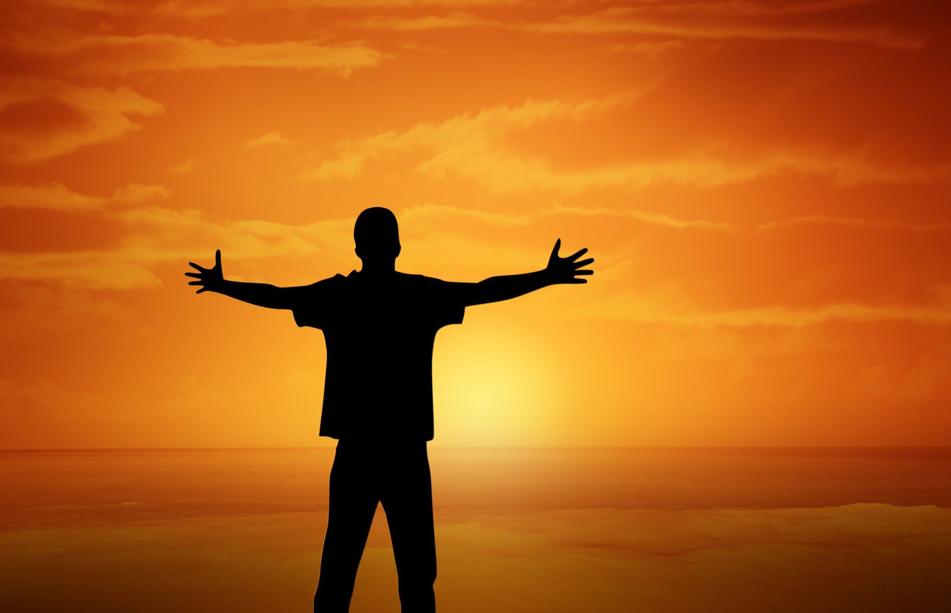 Image of Man with open arms at sunset